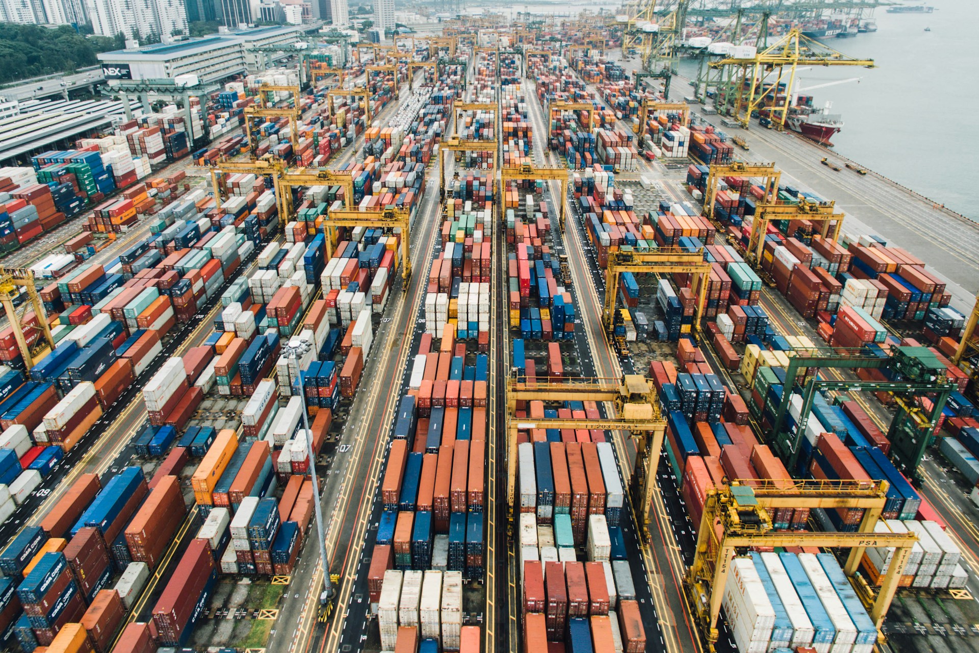 Aerial view of colorful shipping containers at busy port terminal — global freight tracking and visibility